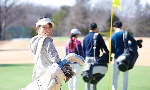 チームでゴルフをする女性